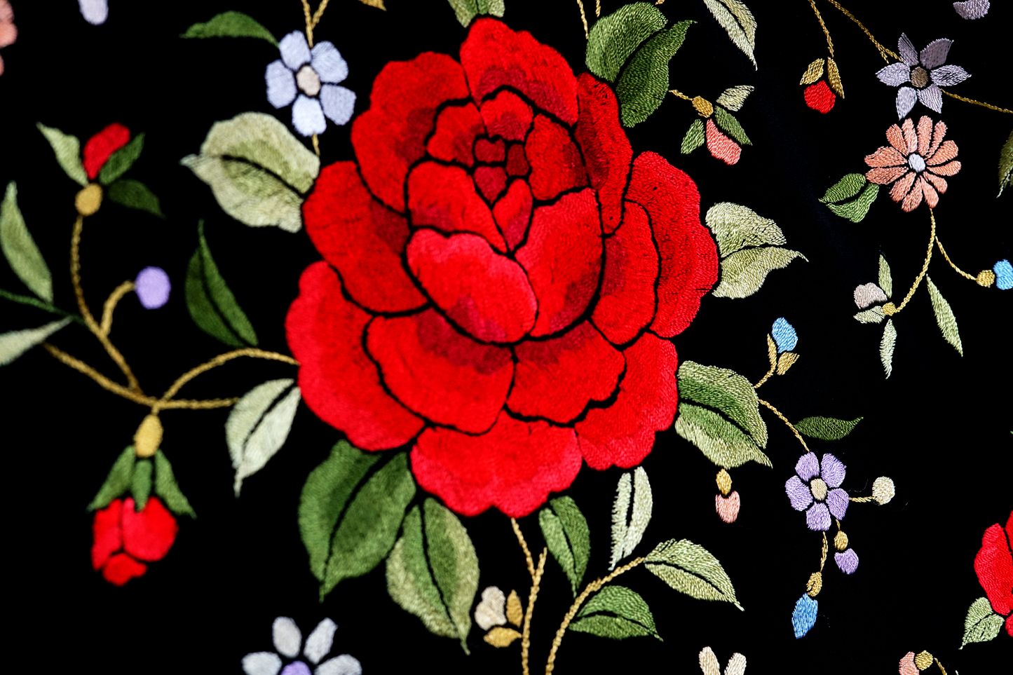 Mantón de seda natural bordado a mano. Fondo negro con bordado multicolor. Formato 135 × 135 cm. Un clásico con fuerza visual.