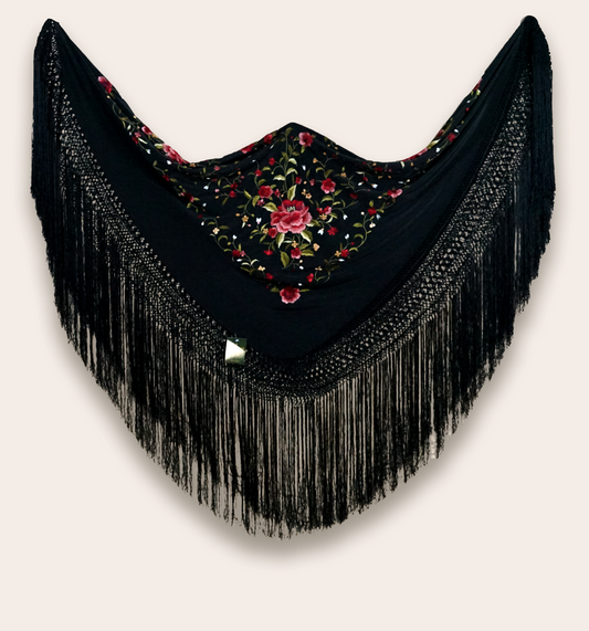 Mantón de seda natural bordado a mano. Diseño sobrio en fondo negro con bordado multicolor. Pieza de 135 × 135 cm con carácter artesanal.
