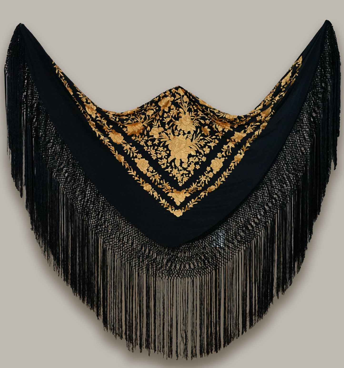 Mantón de seda natural bordado a mano. Fondo negro con bordado en tono cobre. Pieza elegante y poderosa de 135 × 135 cm.