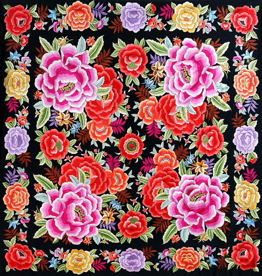 Mantón de seda natural bordado a mano. Bordado multicolor sobre fondo negro en formato 135 × 135 cm. Tradición vibrante con nombre propio.