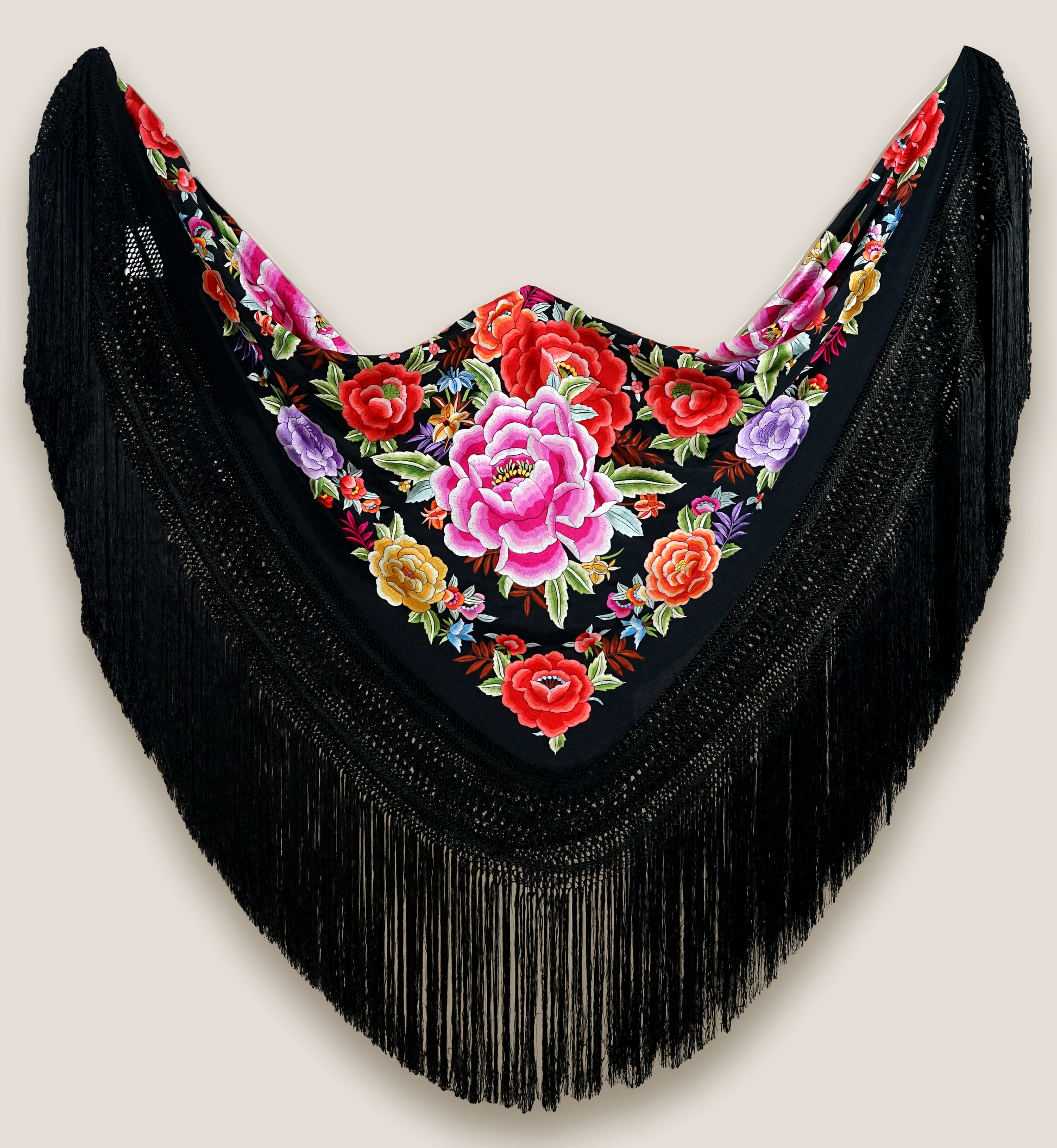 Mantón de seda natural bordado a mano. Bordado multicolor sobre fondo negro en formato 135 × 135 cm. Tradición vibrante con nombre propio.