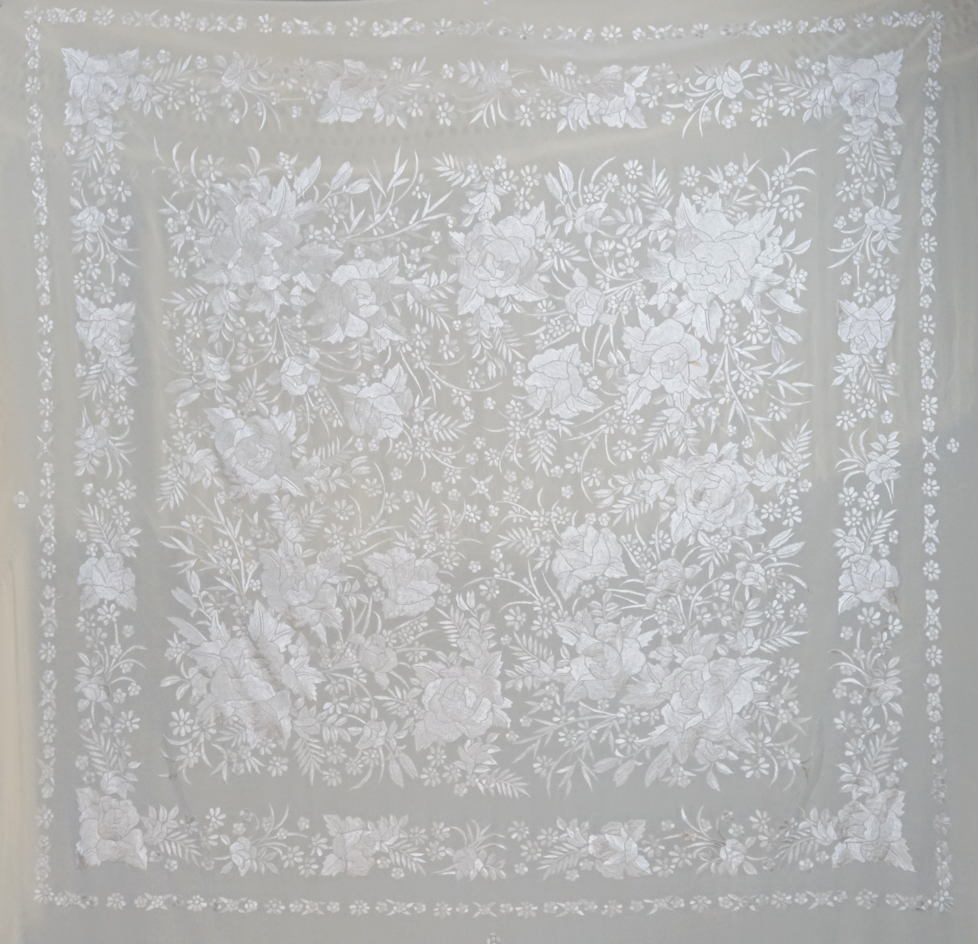 Mantón de seda natural bordado a mano. Pieza en seda color crema con bordado al tono. 135 × 135 cm de delicadeza y elegancia atemporal.