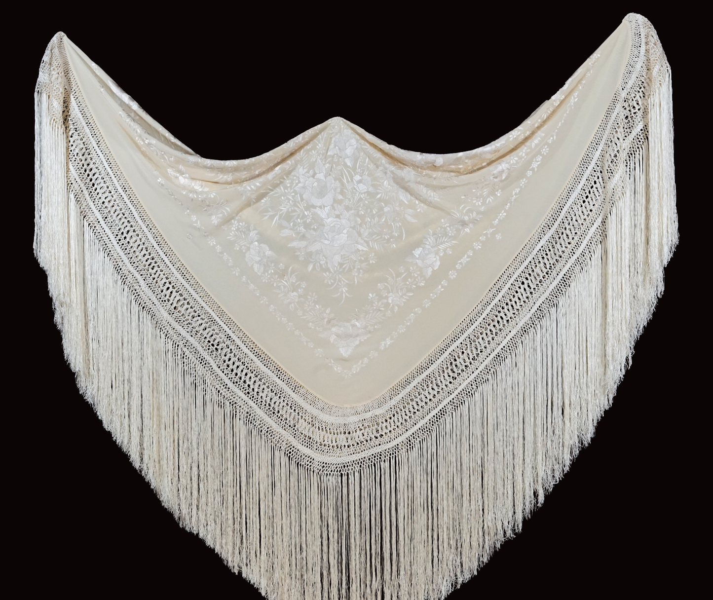 Mantón de seda natural bordado a mano. Pieza en seda color crema con bordado al tono. 135 × 135 cm de delicadeza y elegancia atemporal.