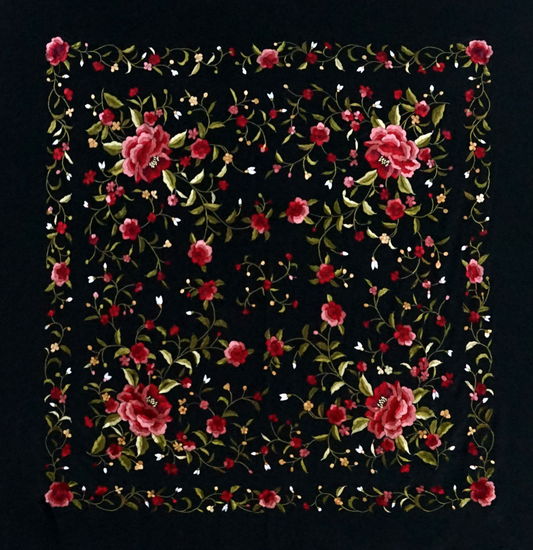 Mantón de seda natural bordado a mano. Diseño sobrio en fondo negro con bordado multicolor. Pieza de 135 × 135 cm con carácter artesanal.