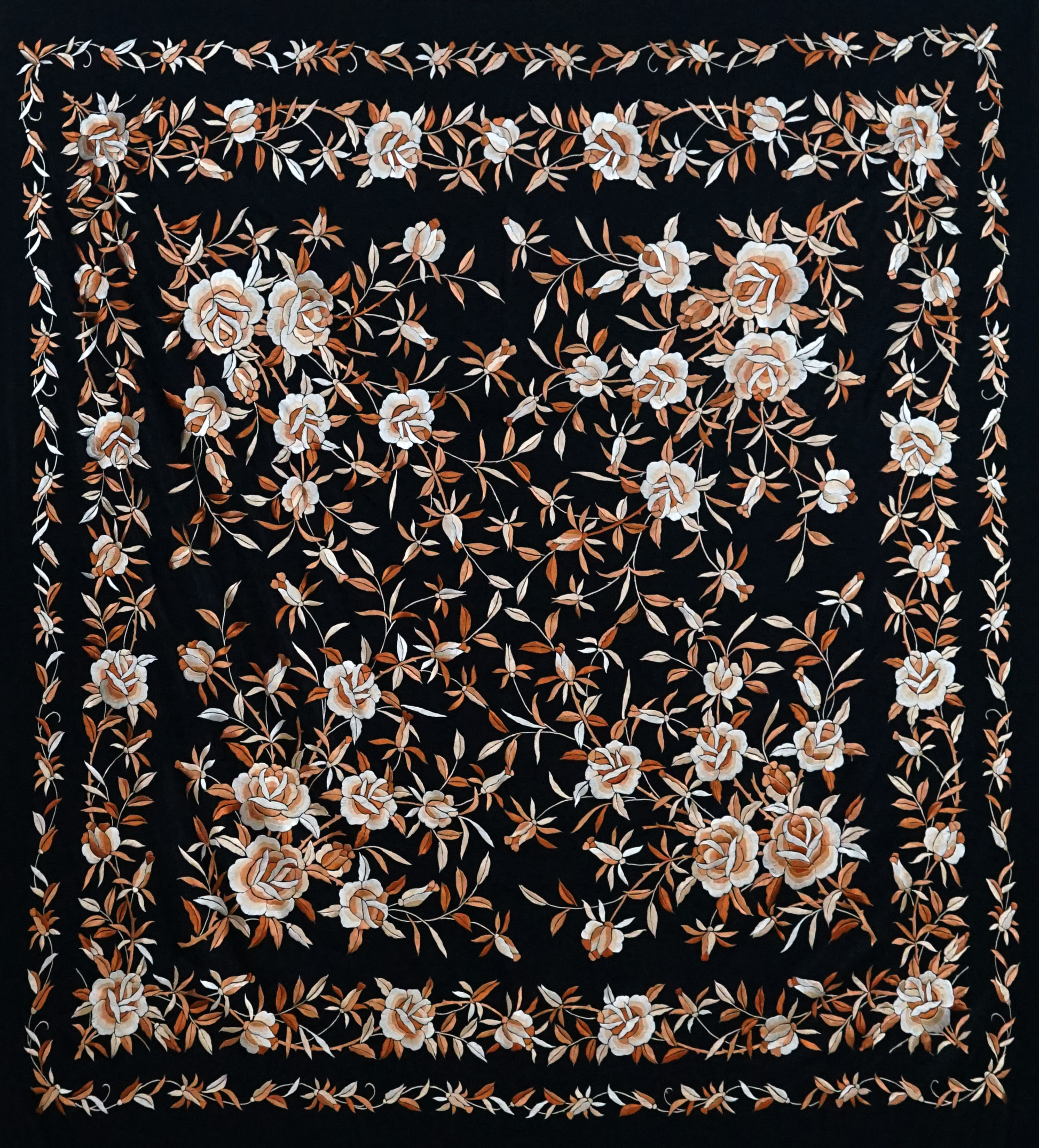 Mantón de seda natural bordado a mano. Diseño sobrio de 135 × 135 cm con fondo negro y bordado en tono crema rebajado. Elegancia serena y artesanal.