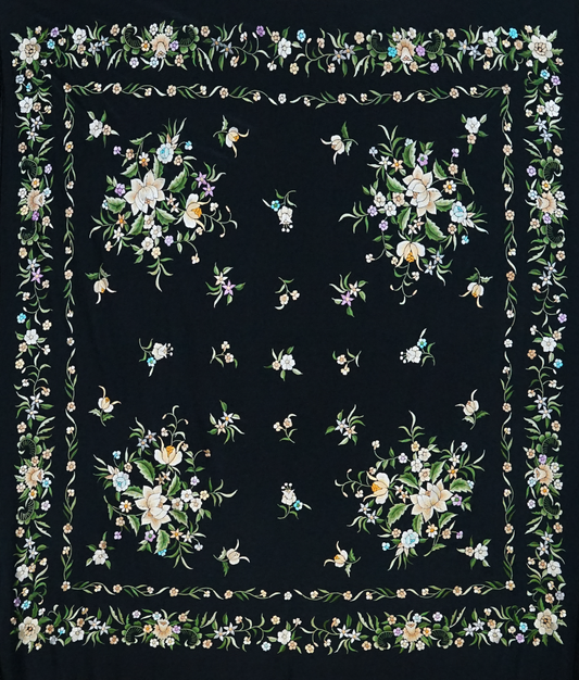 Mantón de seda natural bordado a mano. Clásico fondo negro con bordado multicolor. Formato 135 × 135 cm. Tradición con identidad.