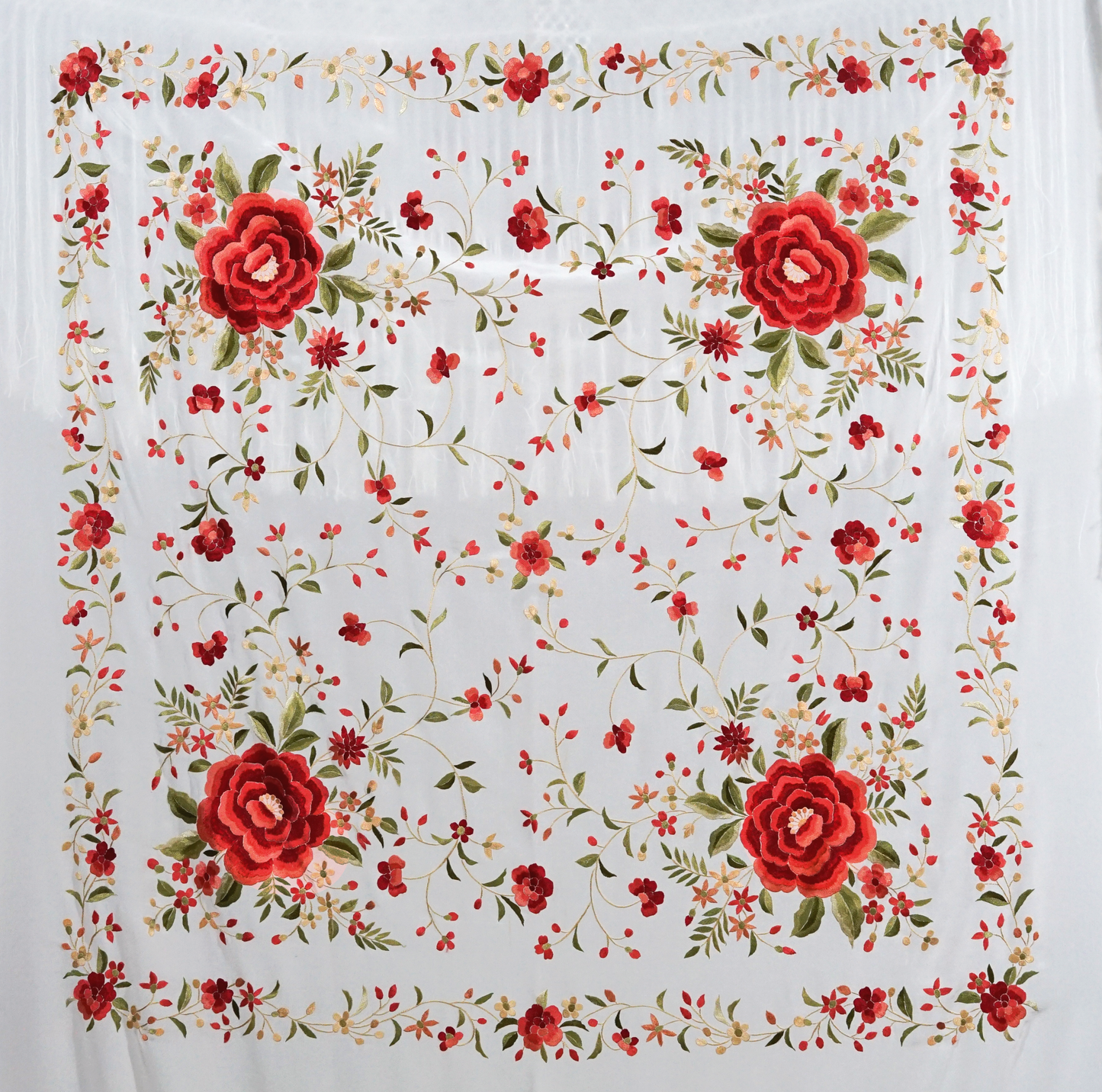 Mantón de seda natural bordado a mano. Diseño artesanal de 135 × 135 cm en seda blanca con bordado multicolor. Sofisticación luminosa con acento festivo.