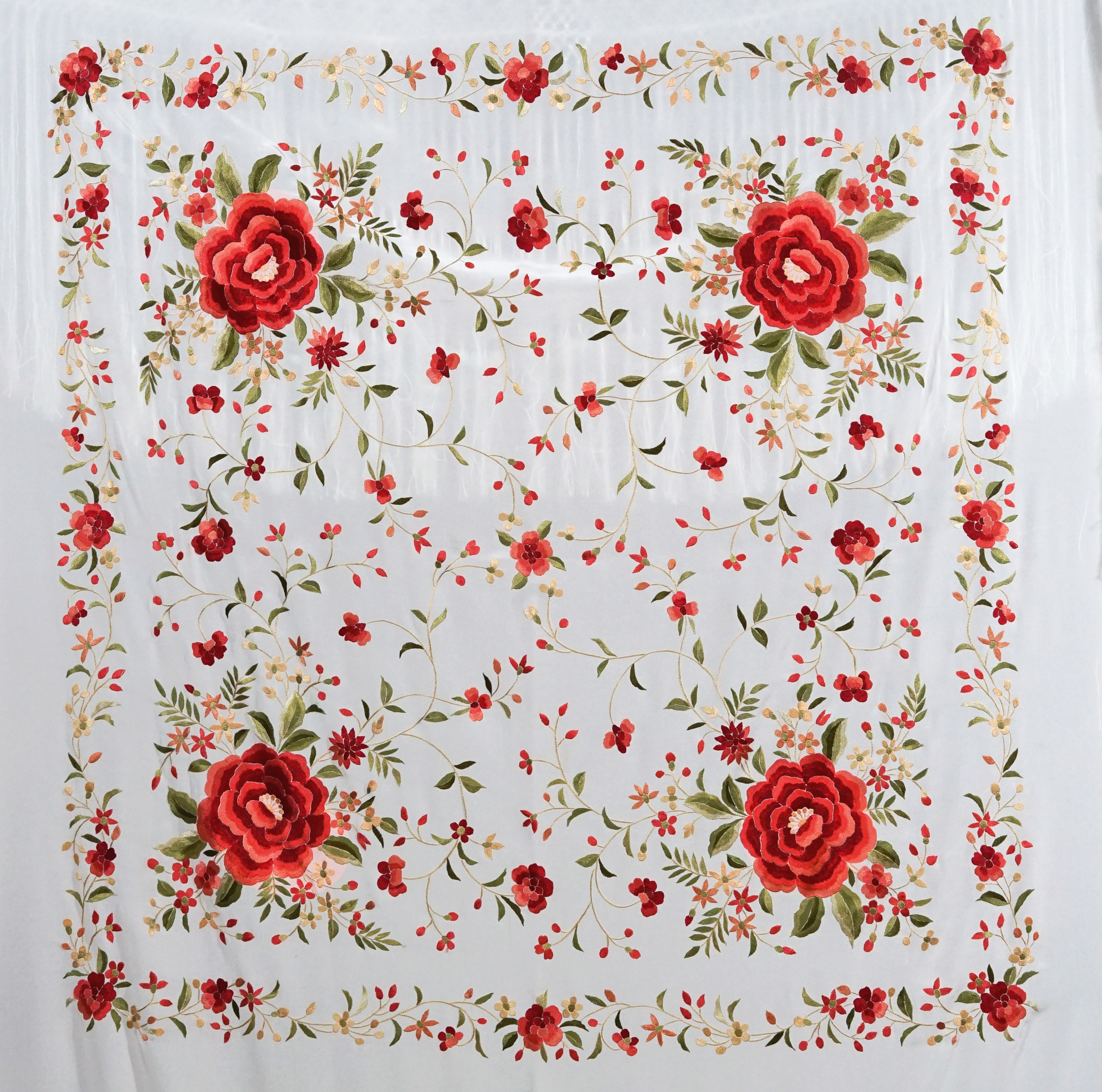 Mantón de seda natural bordado a mano. Diseño artesanal de 135 × 135 cm en seda blanca con bordado multicolor. Sofisticación luminosa con acento festivo.