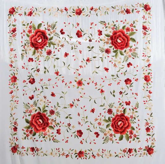 Mantón de seda natural bordado a mano. Diseño artesanal de 135 × 135 cm en seda blanca con bordado multicolor. Sofisticación luminosa con acento festivo.