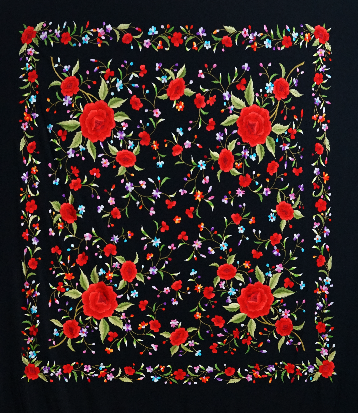 Mantón de seda natural bordado a mano. Diseño sobrio de 135 × 135 cm. Fondo negro con bordado multicolor. Tradición y arte textil unidos.