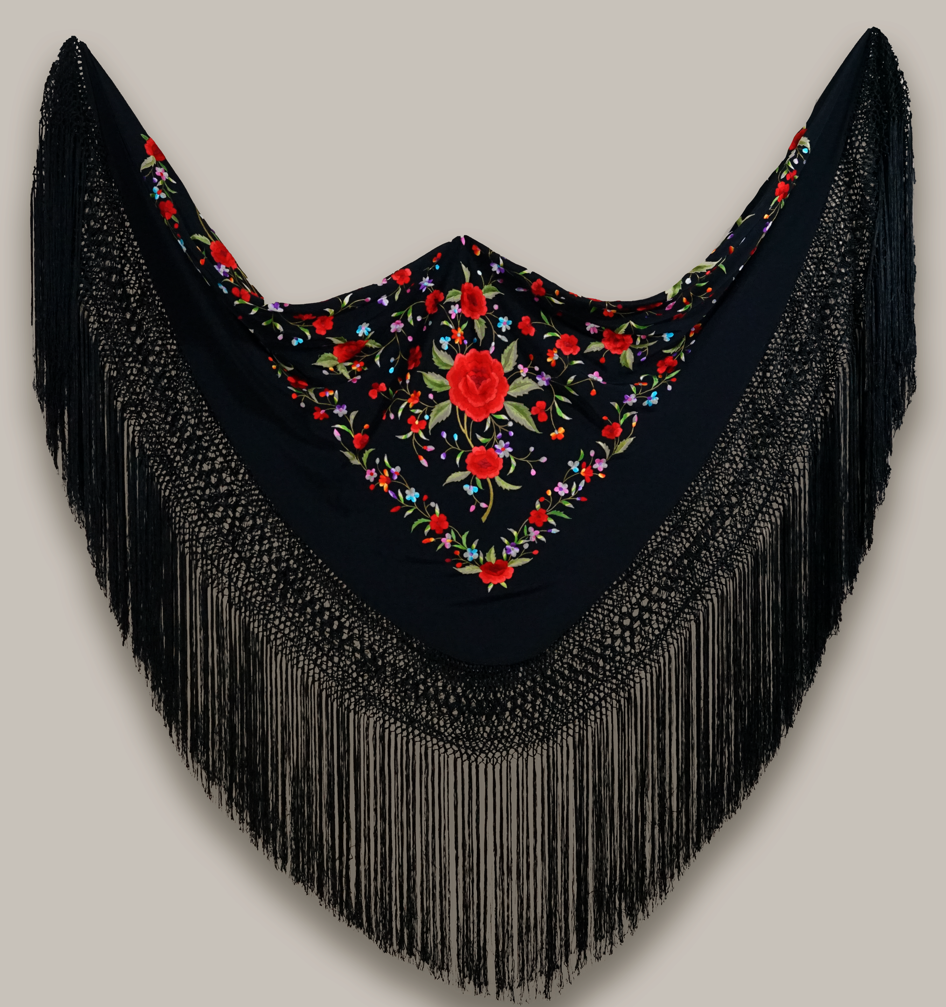 Mantón de seda natural bordado a mano. Diseño sobrio de 135 × 135 cm. Fondo negro con bordado multicolor. Tradición y arte textil unidos.