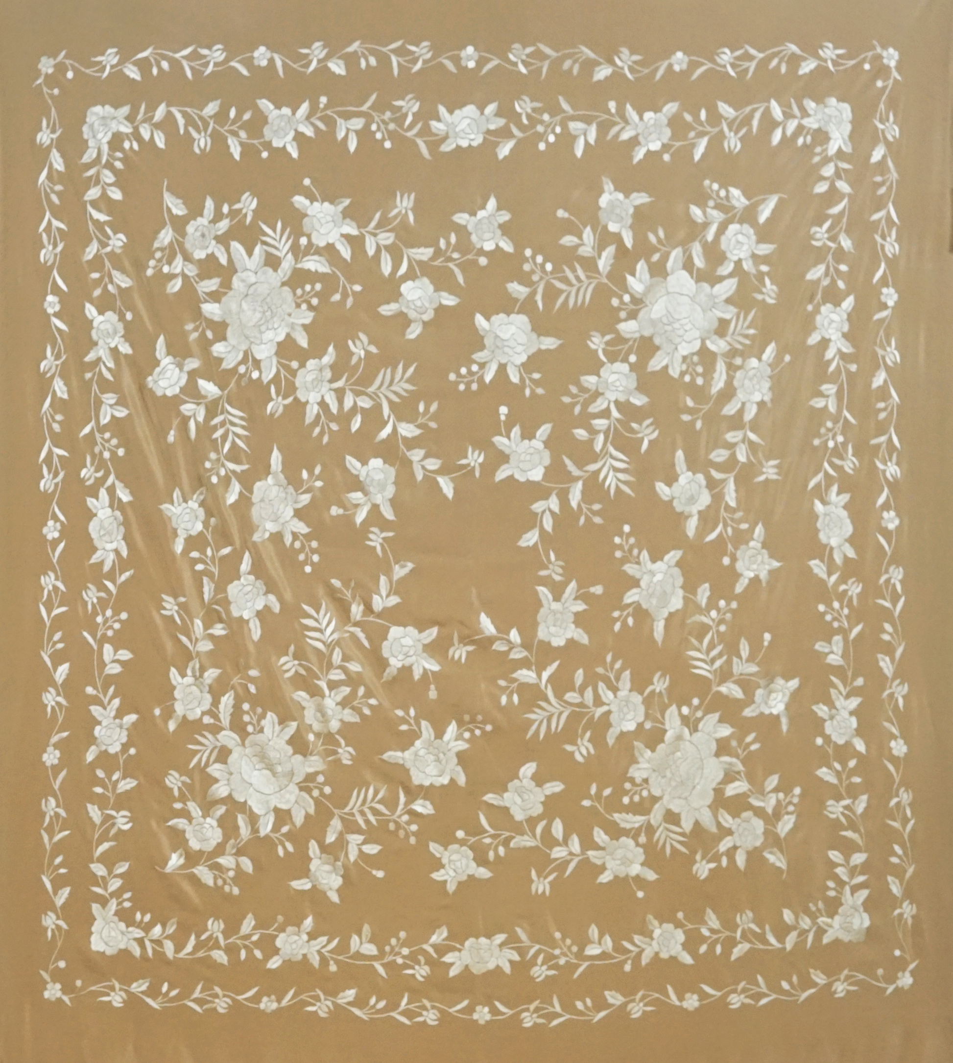 Mantón de seda natural bordado a mano. Pieza en seda tostada con bordado al tono. Formato 135 × 135 cm. Armonía neutra con identidad.