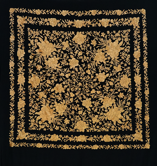 Mantón de seda natural bordado a mano. Fondo negro con bordado en tono cobre. Pieza elegante y poderosa de 135 × 135 cm.