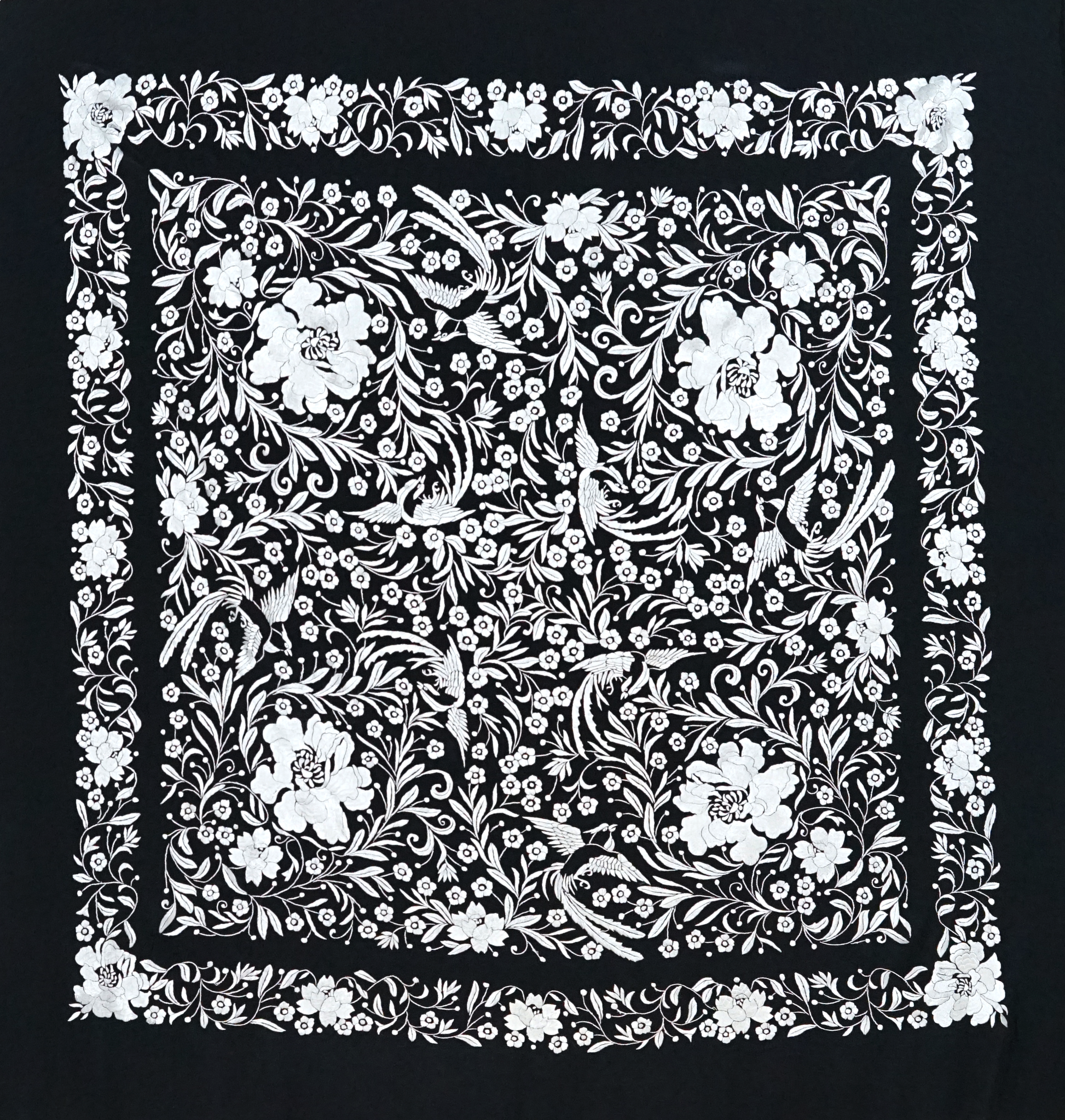 Mantón de seda natural bordado a mano. Contraste elegante: seda negra con bordado blanco. Formato 135 × 135 cm.