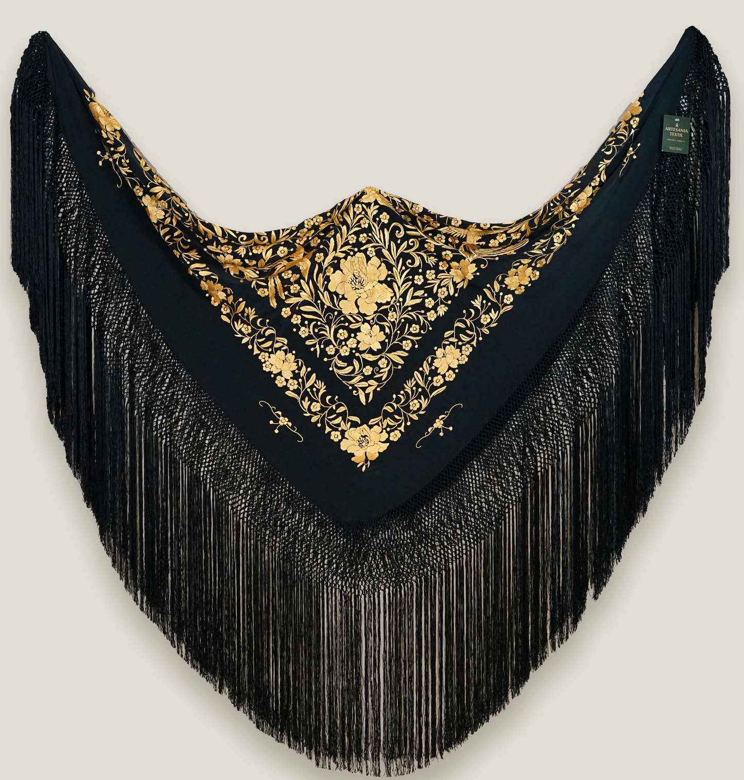 Mantón de seda natural bordado a mano. Pieza de 135 × 135 cm. Fondo negro con bordado en mostaza. Sofisticación cálida y moderna.